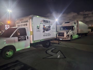 Multiple food trucks parked at night under bright lights at an outdoor event or gathering